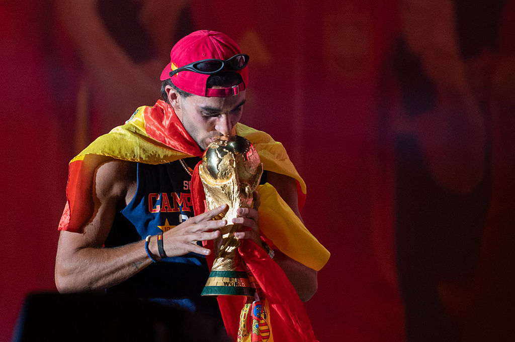 El delantero de la selección española Ferran Torres besa el trofeo durante la celebración del título de campeón de la Copa Mundial de la FIFA en la Plaza de Cibeles.
